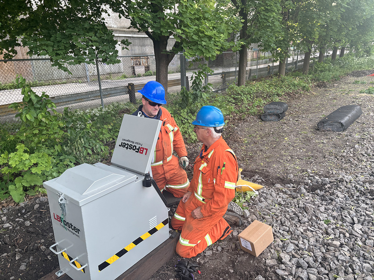 Employees installing the rail lubricators